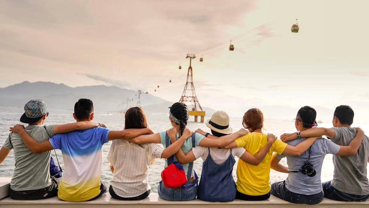 Friends sitting arm in arm at a viewpoint